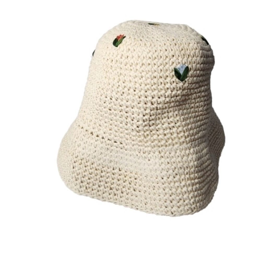Natural-coloured woven straw bucket hat with a shaped crown, photographed on a plain background